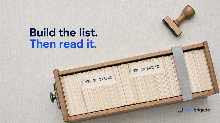 A directly overhead flat-lay in cool even daylight of a long card index drawer pulled open on pale linen, with two rubber-stamped divider tabs standing proud of the packed cards and a steel rule laid across the drawer mouth